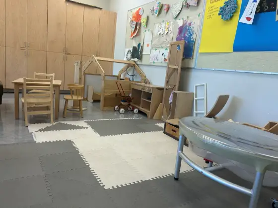 The Butterfly Room play area, with soft floor mats, a child-height wooden table and a sensory table